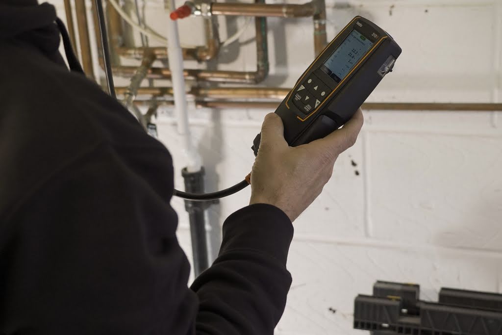 Photo of engineer reading measurement from a hand-held device